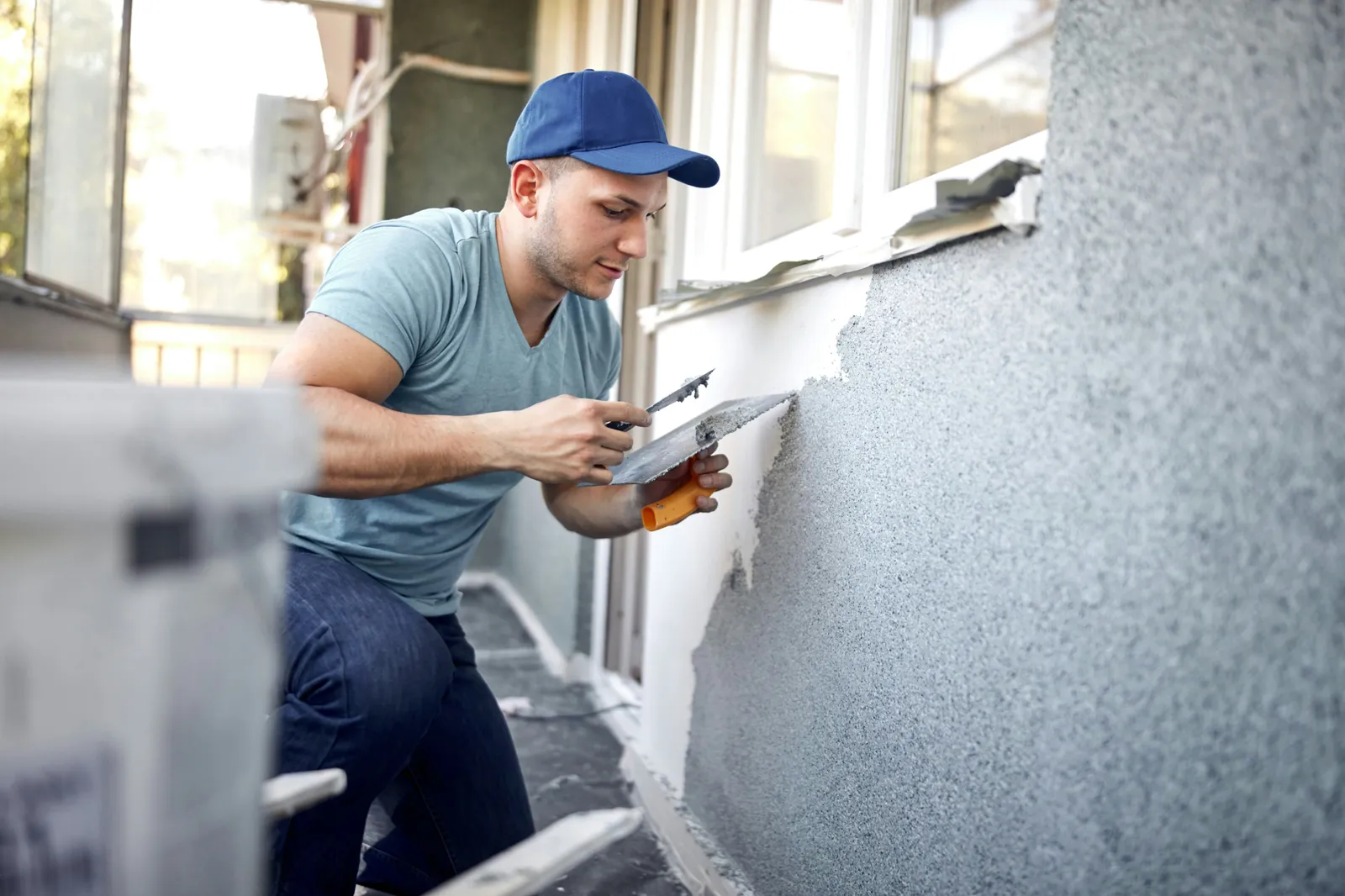 Plasterer applying a smooth finish coat to a bare wall