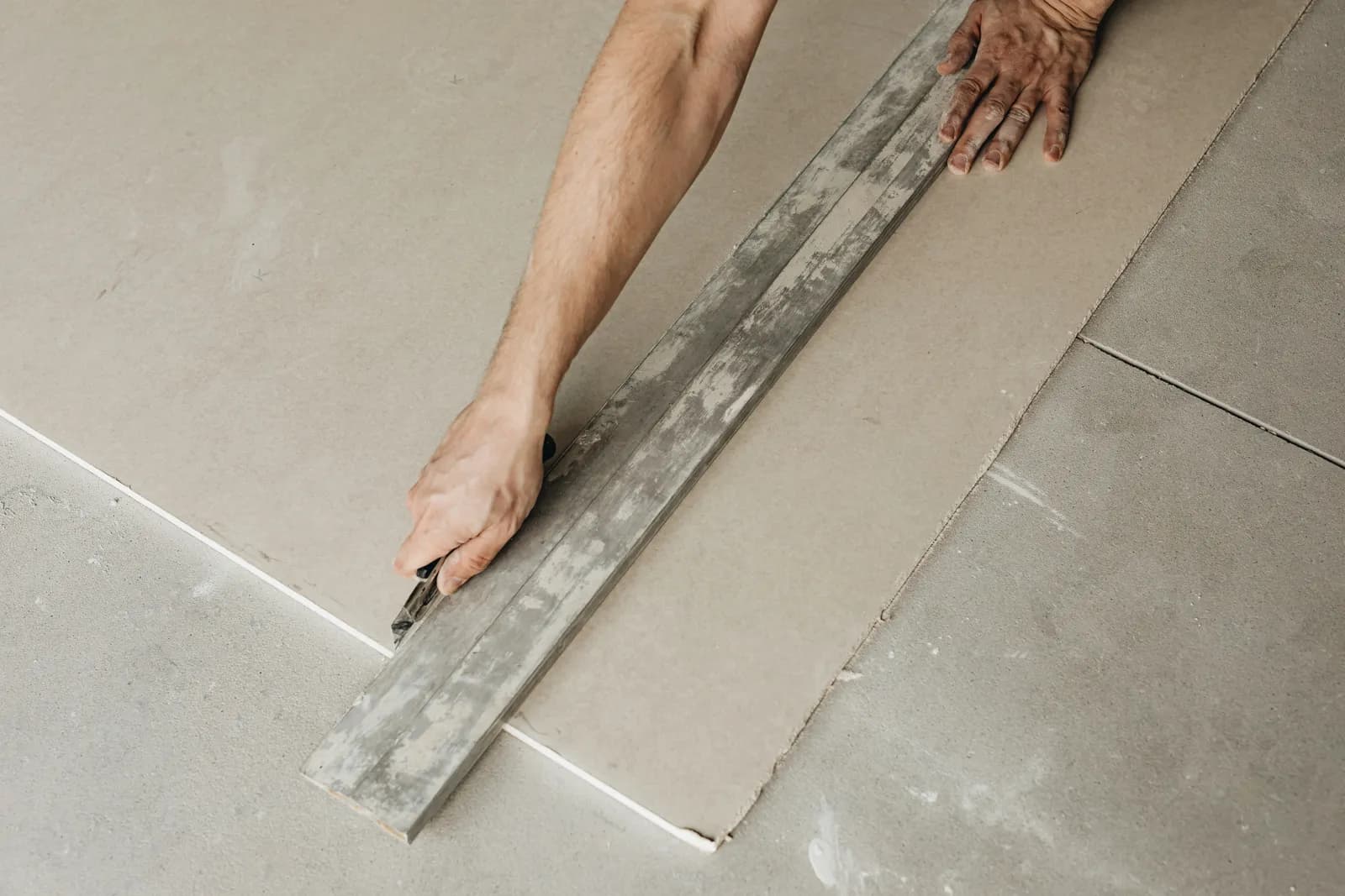 Plasterboard being dot-and-dabbed onto a masonry wall